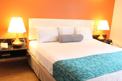 a bedroom with a large white bed with two lamps at Howard Johnson by Wyndham Lake George in Lake George