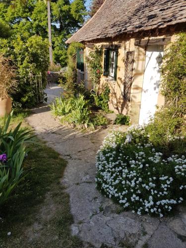 a house with white flowers in front of it at Le Clos Des Etoiles in Le Bugue