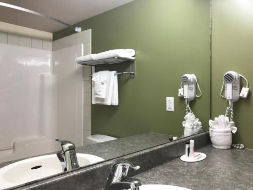 a bathroom with a sink and a mirror at Super 8 by Wyndham Amherst NS in Amherst