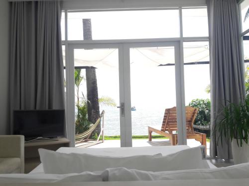 a bedroom with a view of the ocean at TS Beach House in Phu Quoc