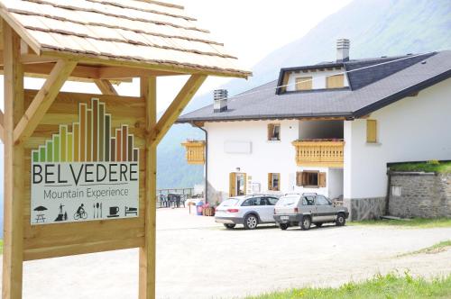 a sign for a mountain experience in front of a building at Belvedere Mountain Experience in Monno