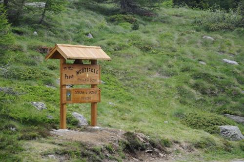 a wooden sign on the side of a mountain at Belvedere Mountain Experience in Monno