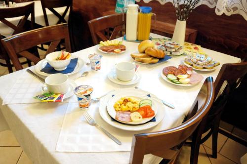 uma mesa com pratos de comida para o pequeno almoço em Corvin Panzio em Gyor