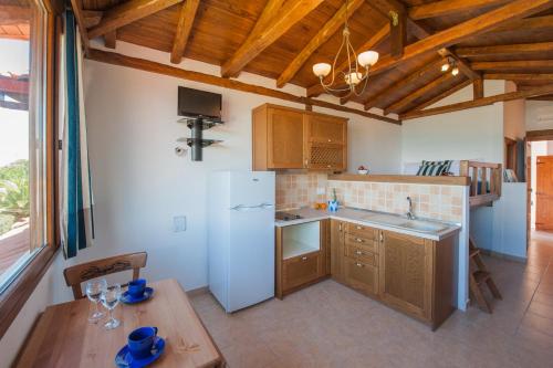 a kitchen with a white refrigerator and a table at Kamares House Apartments & Studios in Vourvourou