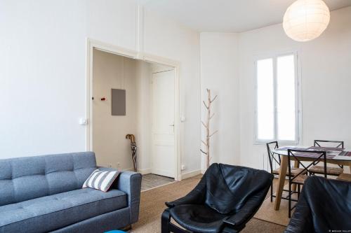 un salon avec un canapé bleu et une table dans l'établissement Martinique Nice apartment, à Bordeaux