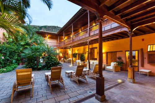 a patio of a house with chairs and tables at Hotel LIVVO La Quinta Roja in Garachico