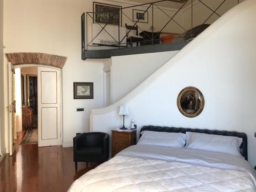 een slaapkamer met een wit bed en een zwarte stoel bij B&B Palazzo Conforti in Salerno