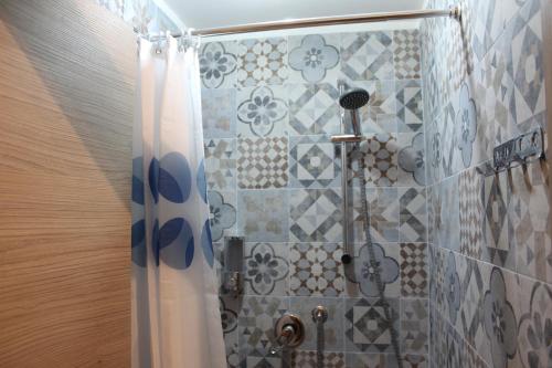 a shower with a shower curtain in a bathroom at Home Genoa Hostel in Genova