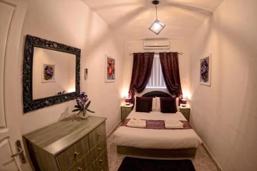 Habitación pequeña con 2 camas y espejo. en Village Corner 3 bedroom apartment with Garage, en Marsaskala