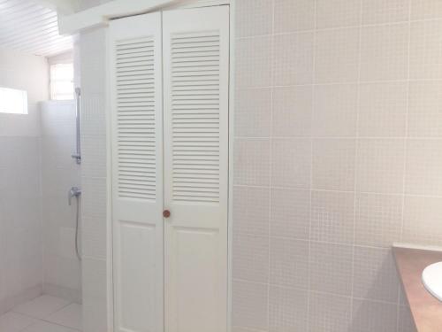 a white cabinet in a bathroom with a sink at La Rose du Bresil Marie-Galante in Capesterre-de-Marie-Galante