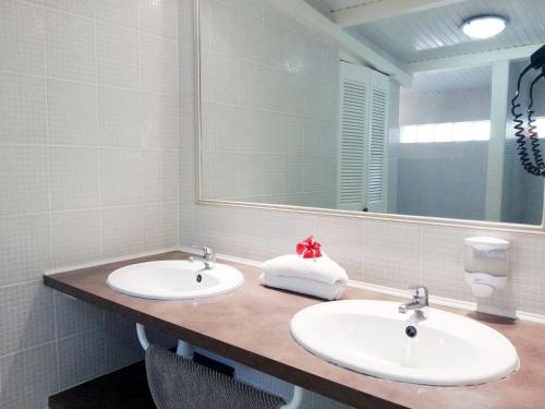 a bathroom with two sinks and a mirror at La Rose du Bresil Marie-Galante in Capesterre-de-Marie-Galante