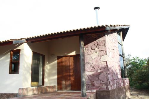 a house with a stone and wooden door at Pousada Terras do Poente in Vale do Capao