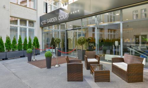 a store front of a building with chairs and plants at Hotel Garden Court in Prague
