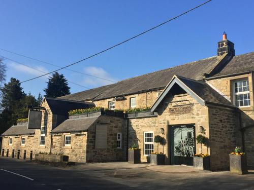 an old stone building with a door on a street at Battlesteads in Wark