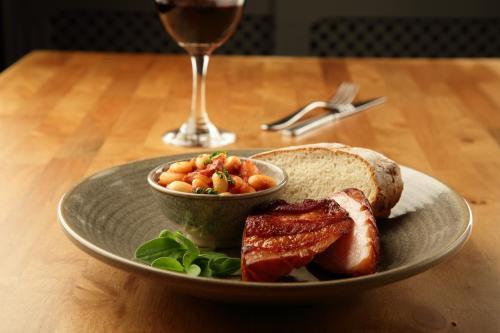a plate of food with a sandwich and a glass of wine at Battlesteads in Wark