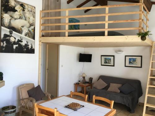 Sala de estar con cama elevada y mesa en Gîtes ruraux Aria Falcona en Santa-Maria-Figaniella
