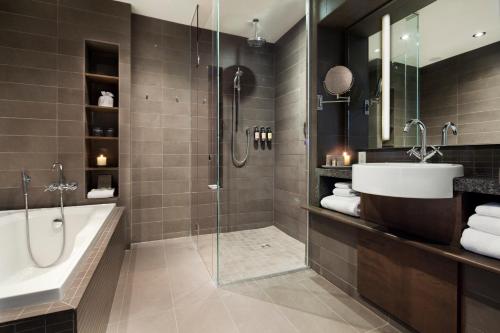 a bathroom with a tub and a sink and a shower at Hotel 71 by Preferred Hotels & Resorts in Quebec City