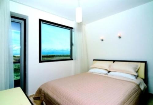 a bedroom with a bed and a window at Belek Golf Apartments in Belek