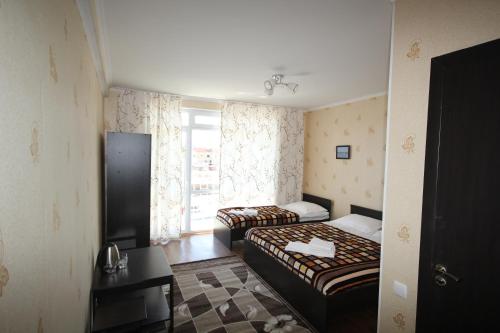 a hotel room with two beds and a window at Parus Hotel in Bosteri