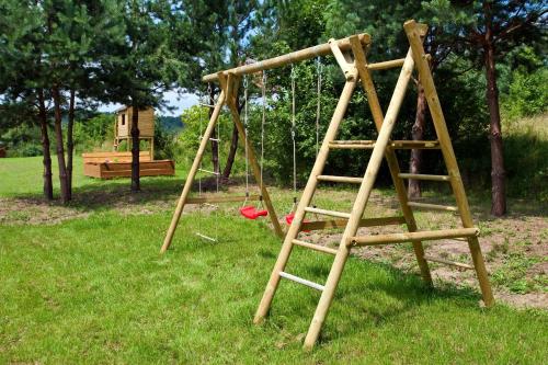 a wooden swing set in a park at Podlesice 38 in Kroczyce