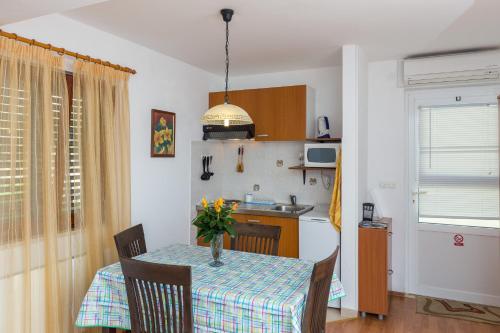 a kitchen with a table with a vase of flowers on it at Apartments Milanović in Cavtat