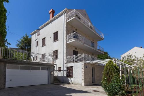 a large white house with a white garage at Apartments Milanović in Cavtat
