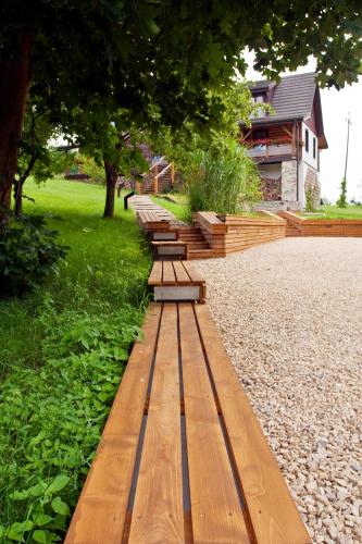 a row of wooden benches in a park at Podlesice 38 in Kroczyce