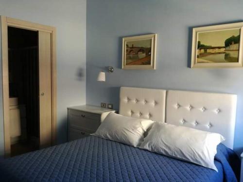 een slaapkamer met een bed met een blauw dekbed bij Casa Garibaldi in Anzio
