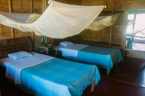 Tempat tidur dalam kamar di Grillo Tres Puntas Eco-Hostel