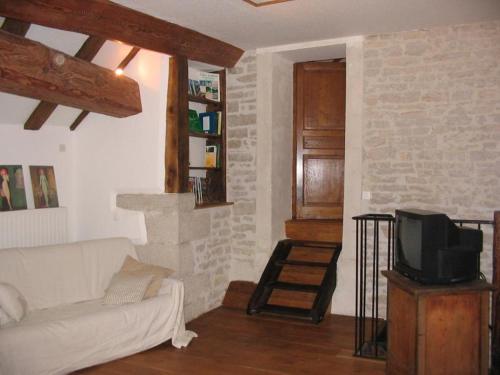 een woonkamer met een witte bank en een tv bij Gite du Repos in Amondans