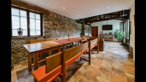 a dining room with a table and a stone wall at La Era in Lario