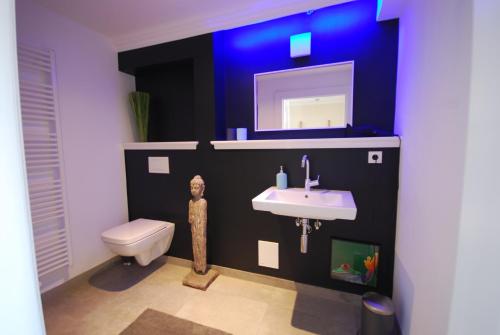 een badkamer met een wastafel, een toilet en een spiegel bij Stadthaus Oldenburg in Oldenburg