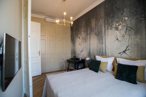 a bedroom with a bed and a wall with birds on it at Broadway Residence in Budapest