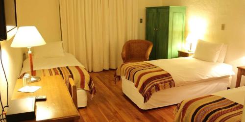 a hotel room with two beds and a desk at Hotel Terraviña in Santa Cruz