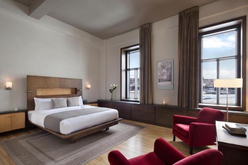 a hotel room with a bed and a red chair at Hotel 71 by Preferred Hotels & Resorts in Quebec City