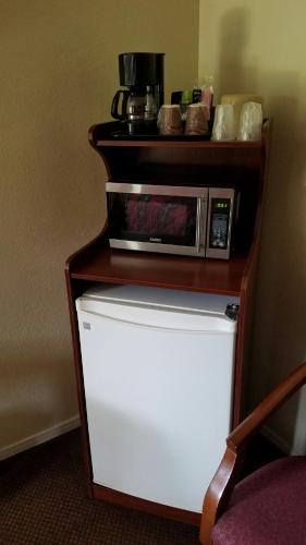 a microwave sitting on top of a refrigerator at Victory Motel Inn near Universal & Hollywood in Glendale