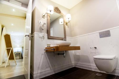 łazienka z umywalką i lustrem na ścianie w obiekcie Natura Petit Hotel w mieście Revolta
