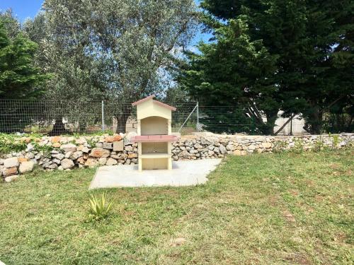 a small bird house in a yard with a stone wall at Trullo Grazioso Luxury in Ceglie Messapica