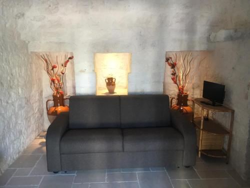 a living room with a couch and a television at Trullo Grazioso Luxury in Ceglie Messapica