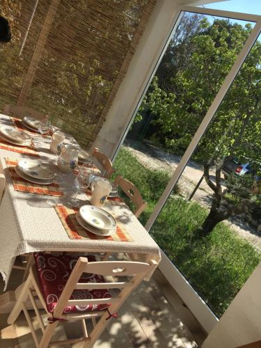a table with plates and dishes on it next to a window at Trullo Grazioso Luxury in Ceglie Messapica