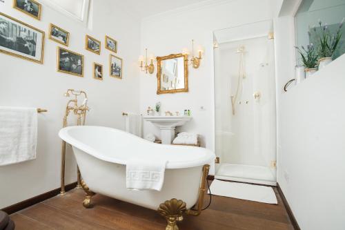 a white bathroom with a tub and a sink at Casa Di Capri in Capri