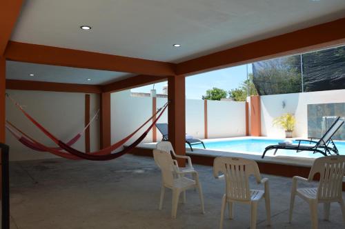 a room with a hammock and a swimming pool at Terracota Corner Rooms in Campeche