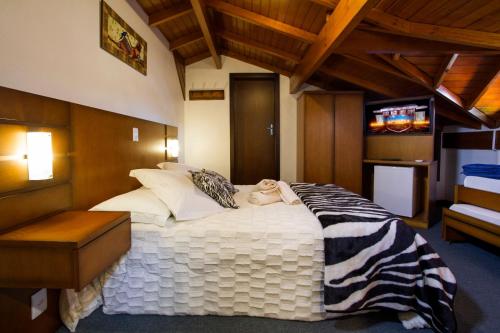 um quarto com uma cama grande e um cobertor de zebra em Pousada Hencke Haus em Canela