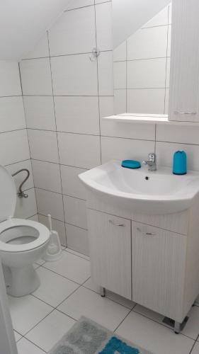 a white bathroom with a sink and a toilet at Eleftheria Sea Side Traditional House in Elounda