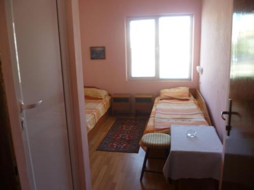 a small room with two beds and a window at Stai Za Gosti Venera in Hisarya