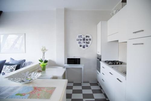 una cocina blanca con suelo a cuadros en blanco y negro en La Casetta Sestri Levante, en Sestri Levante