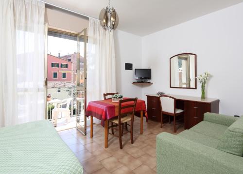 ein Wohnzimmer mit einem Tisch und einem Sofa in der Unterkunft Residence Hotel Kriss in Deiva Marina