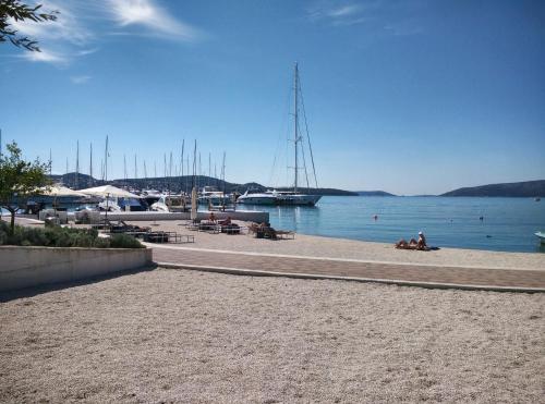 a beach with a sail boat in the water at Apartments Gina in Trogir