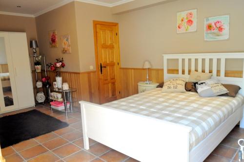 a bedroom with a white bed and a bathroom at Caserio Kamirune in Laukiz