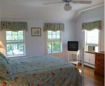 um quarto com uma cama, 2 janelas e uma televisão em Ashley Inn em Edgartown